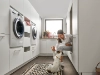 Une femme joue avec un chien dans une buanderie moderne de Nolte Utility Rooms.