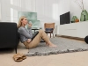 Une femme assise avec une tasse dans un salon moderne avec des meubles Nolte Living.
