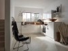 Une cuisine moderne et lumineuse avec des armoires blanches et de grandes fenêtres. Nolte Kitchen.