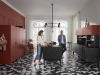 Une cuisine moderne de Nolte Kitchen avec deux personnes, sol en carreaux géométriques et armoires rouges.
