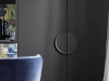 Une élégante armoire avec poignée ronde à côté d'une chaise bleue, de la collection Nolte Living.