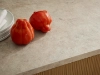 Deux poivrons rouges et une assiette sur un plan de travail dans une cuisine Nolte.