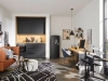 Cuisine moderne avec armoires noires et espace de vie cosy par Nolte Kitchen.