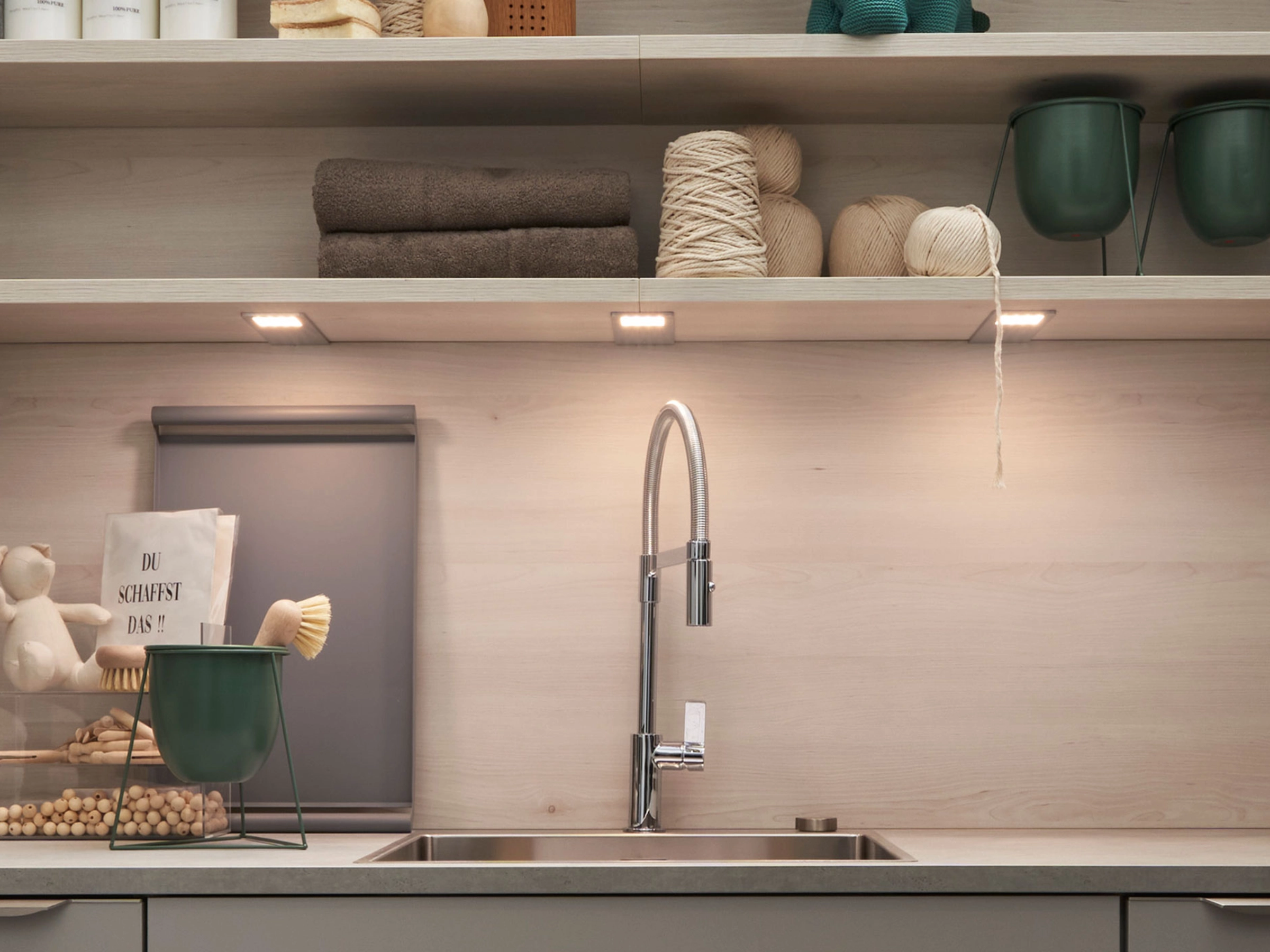 Une cuisine moderne avec étagères en bois et un robinet élégant. Nolte Kitchen.