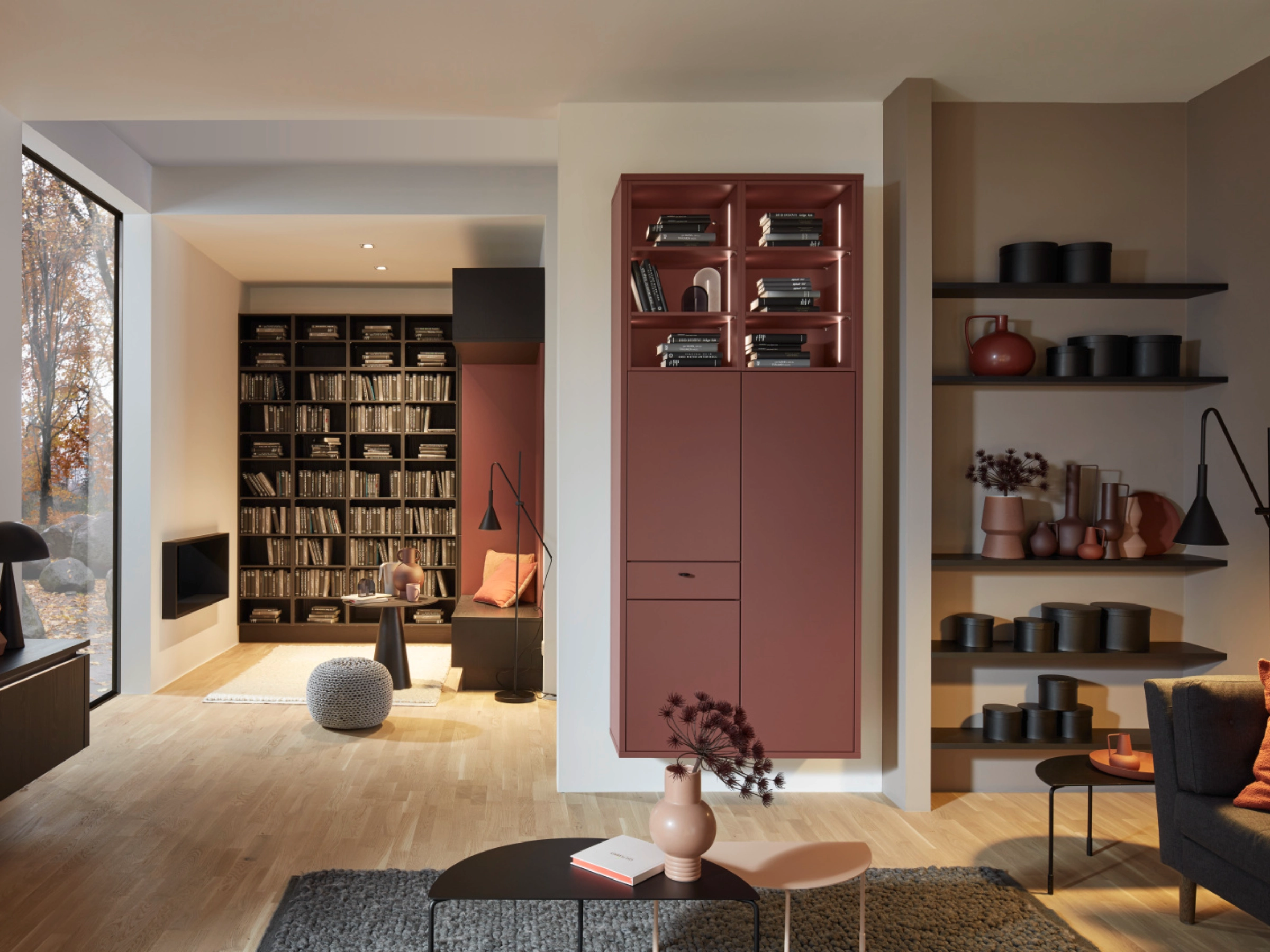 A modern living room with shelves and a cozy seating area, integrated into Nolte Living.