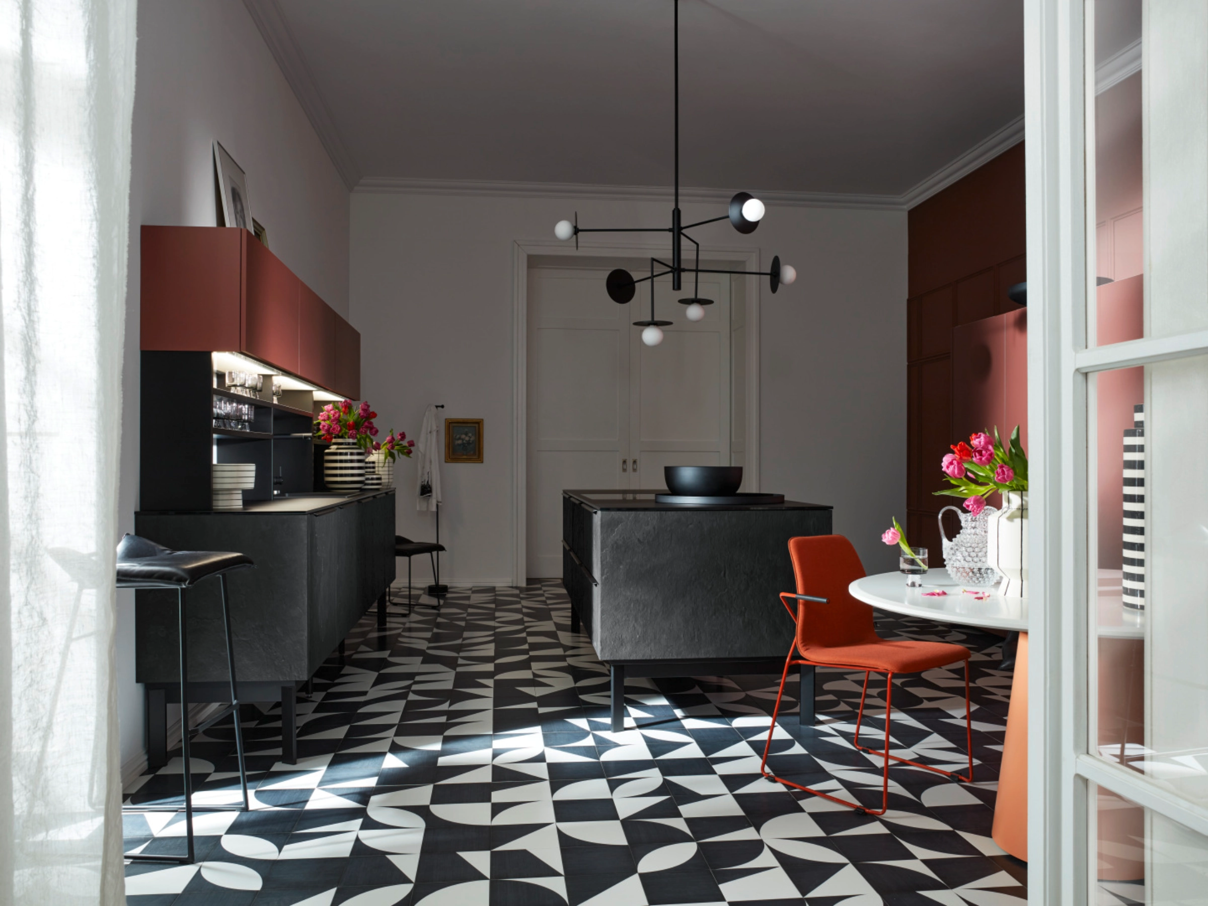 Une cuisine moderne avec sol géométrique et meubles élégants, conçue par Nolte Kitchen.