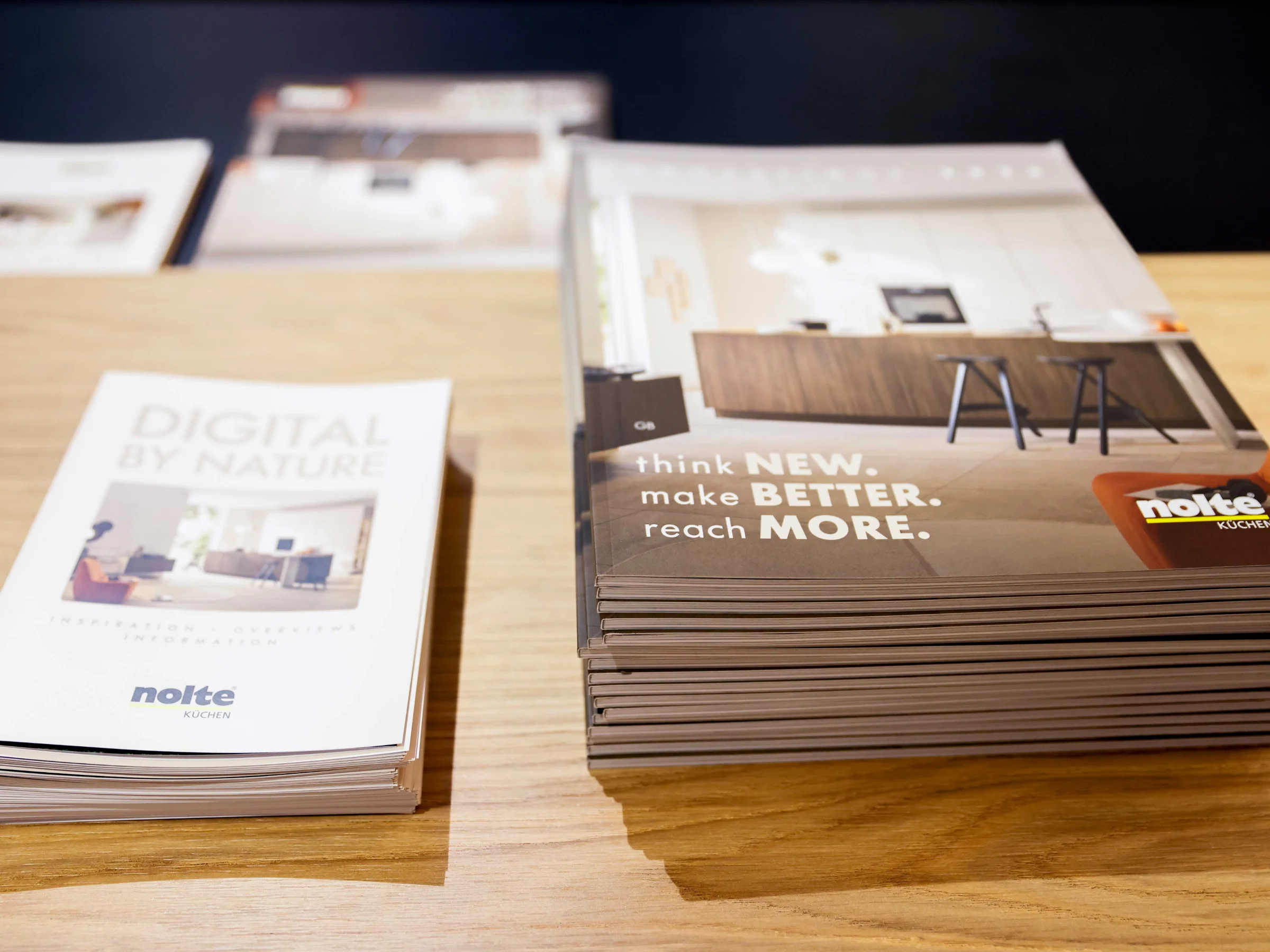 Brochure con design di cucine e logo Nolte Küchen su un tavolo.