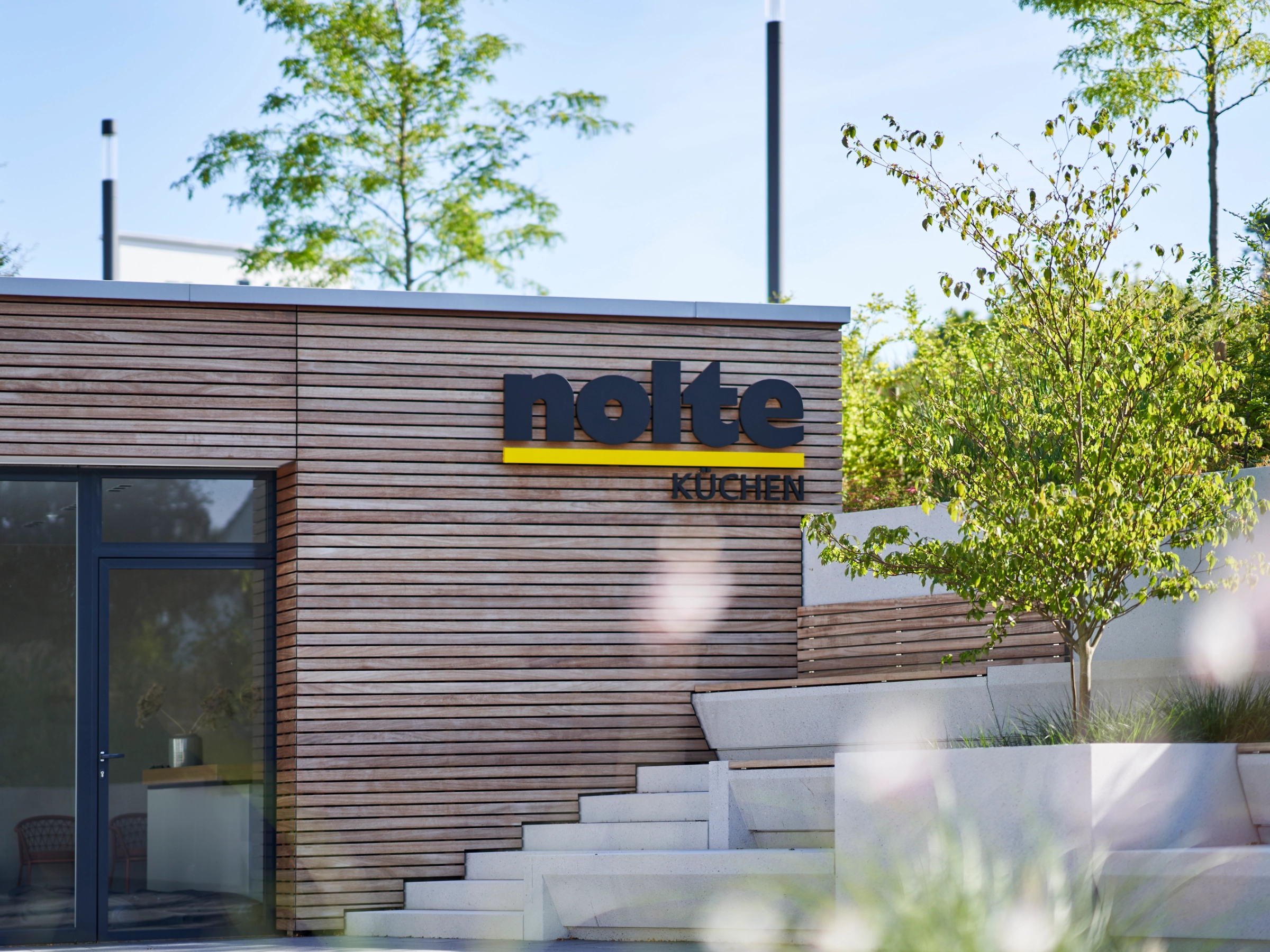 Edificio moderno con facciata in legno e logo di Nolte Kitchen.