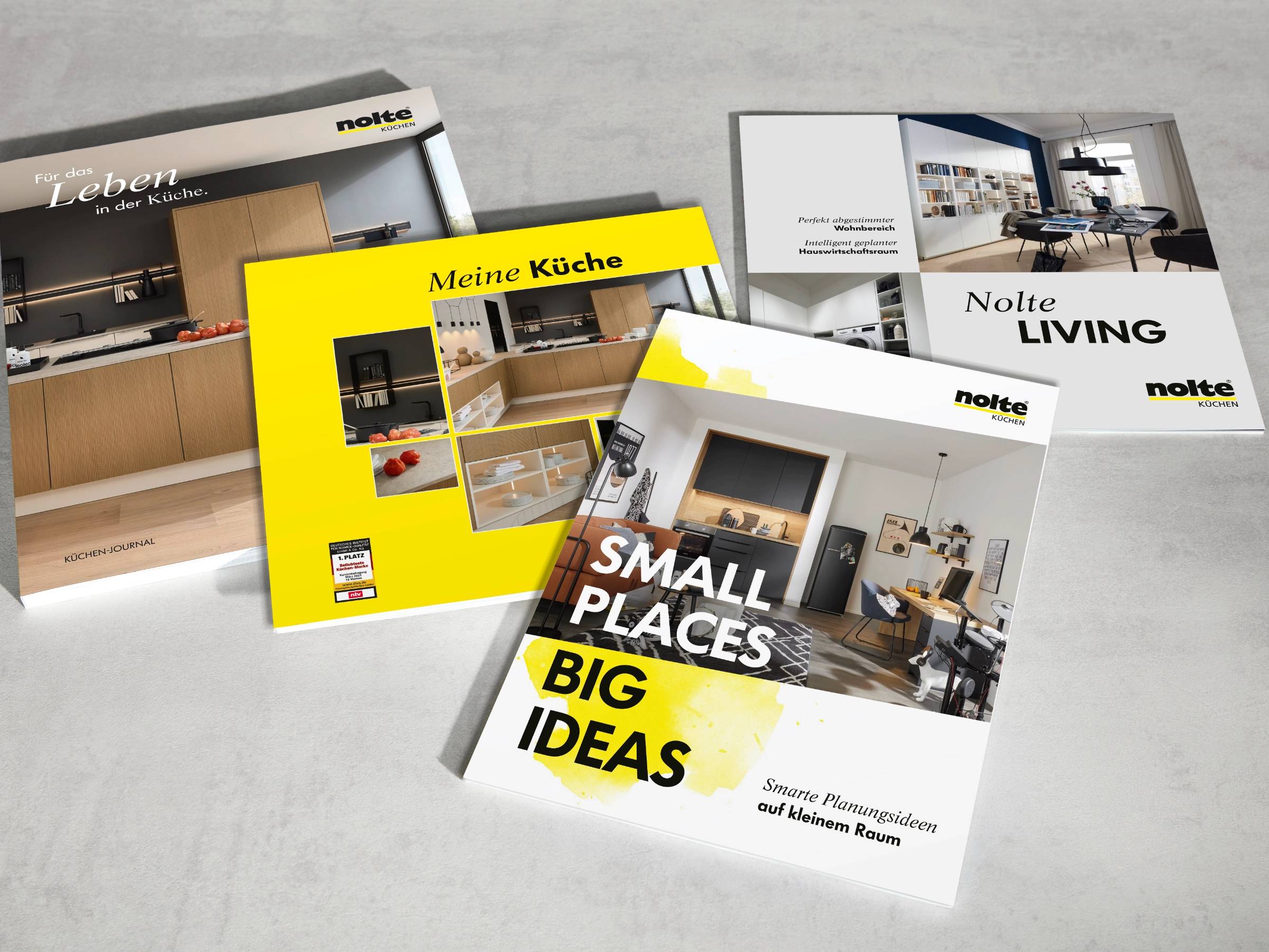 Quatre brochures sur Nolte Kitchen, Nolte Living et NolteNeo Designs sont posées sur une table.