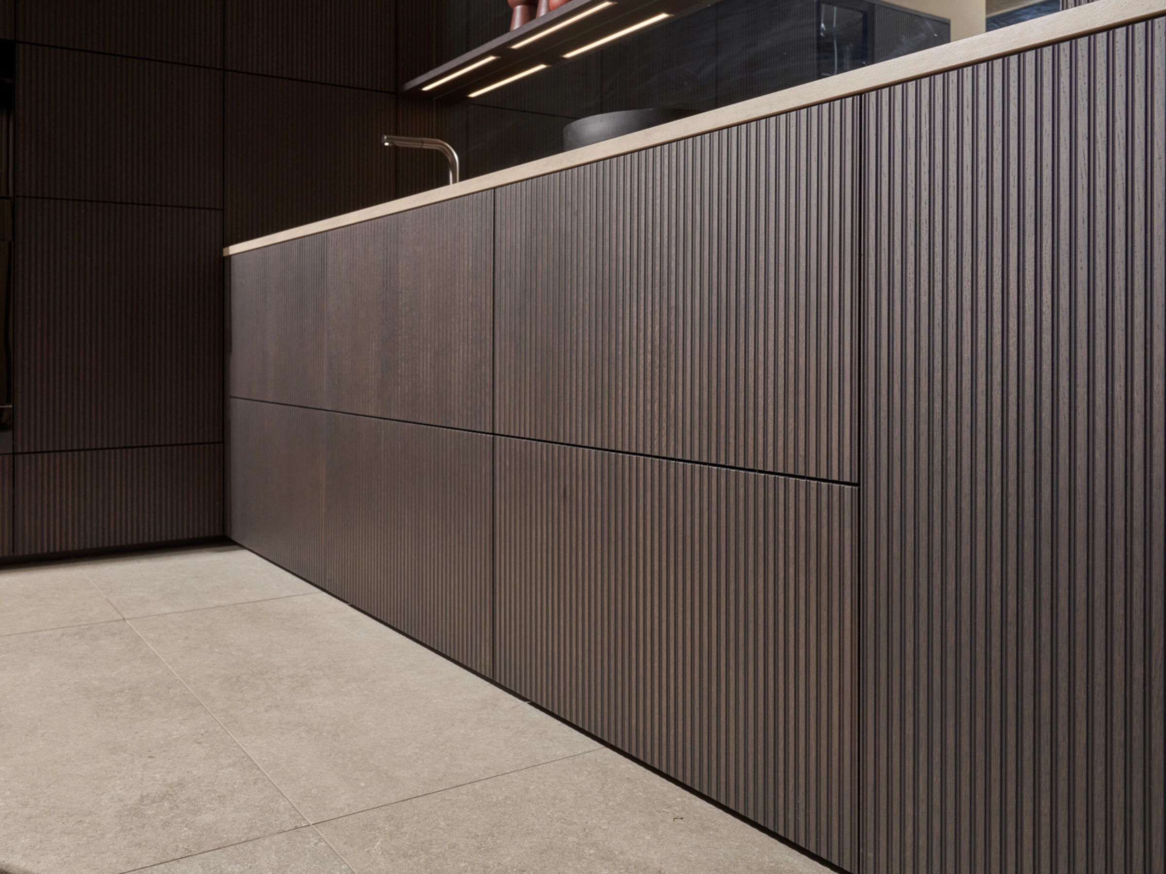 Cuisine moderne avec façades en bois sombre et sol en pierre de Nolte Kitchen.