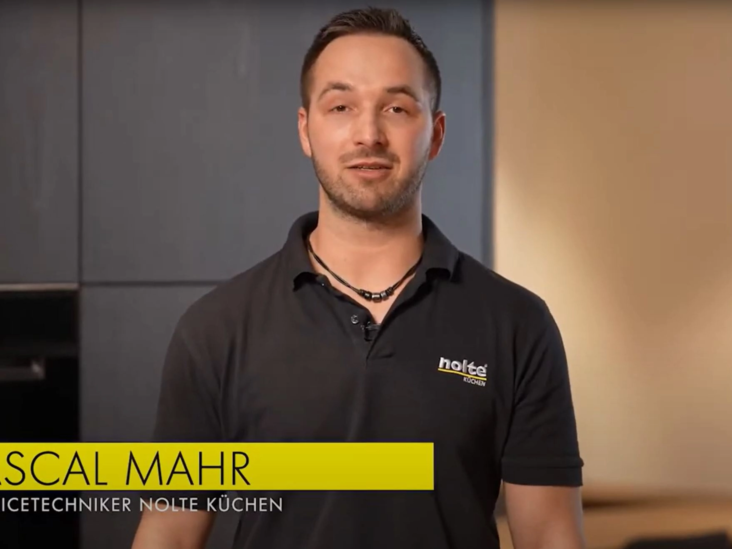 Ein Servicetechniker steht in einer modernen Küche von Nolte Küchen.