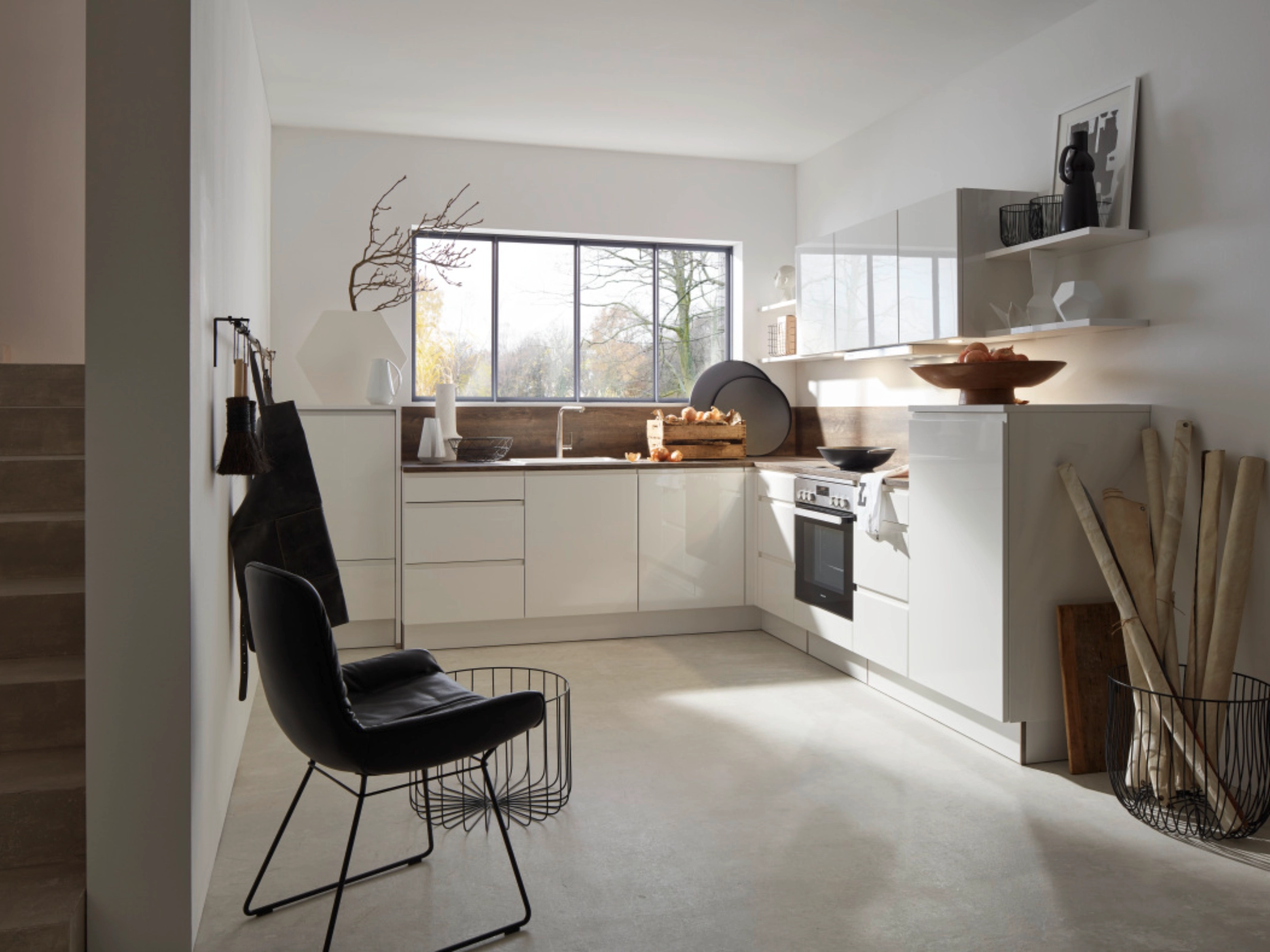 Une cuisine moderne et lumineuse avec des armoires blanches et de grandes fenêtres. Nolte Kitchen.