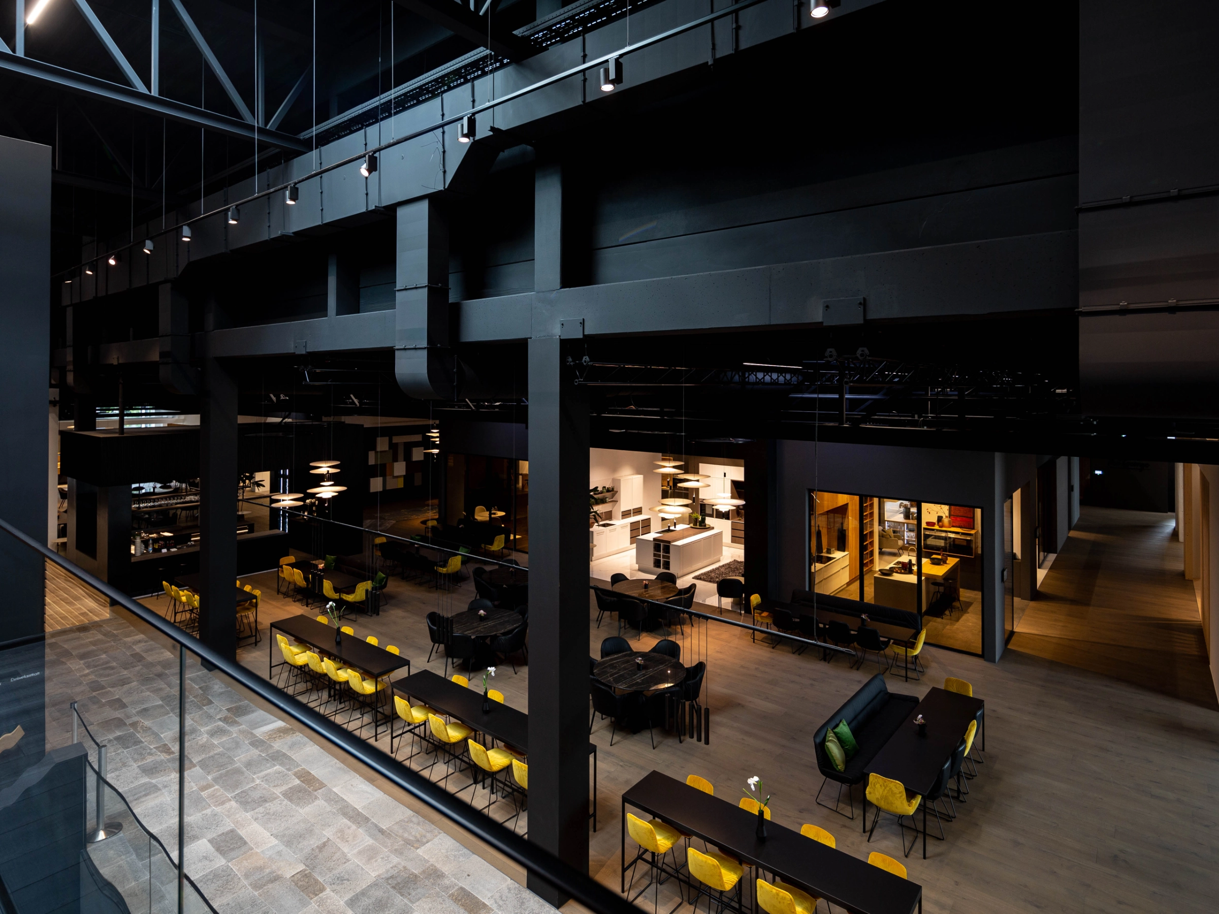 Une grande salle moderne avec de longues tables et des chaises jaunes, idéale pour Nolte Living.