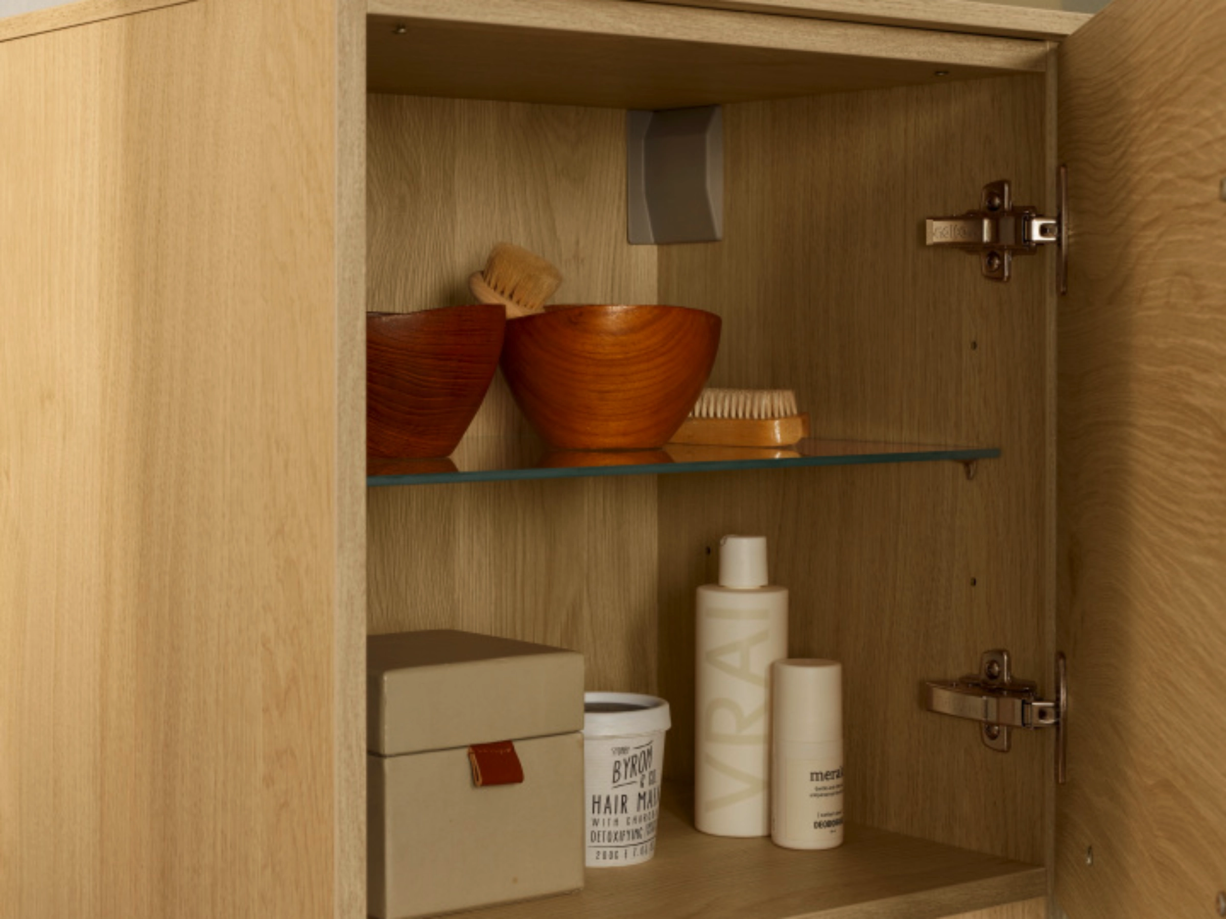 Een open badkamerkast met verzorgingsproducten en handdoeken, Nolte SPA.