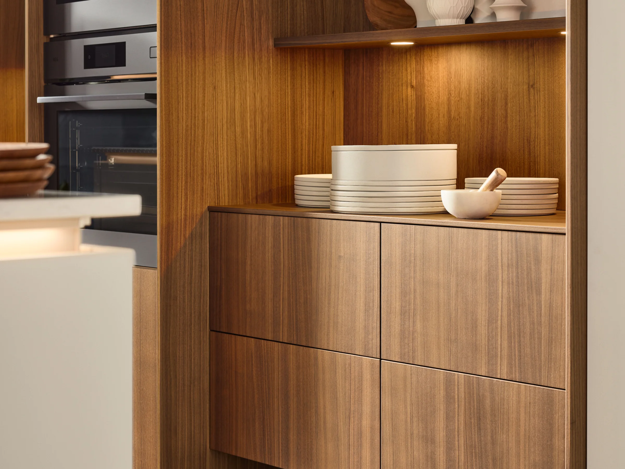 Eine moderne Küche mit Holzschränken und integriertem Backofen von Nolte Küchen.