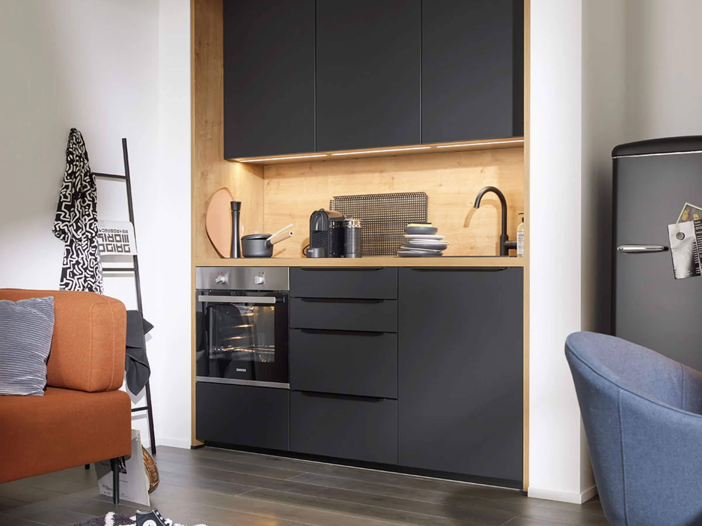 Eine moderne Küche mit schwarzen Schränken und Holzdetails von Nolte Küchen.