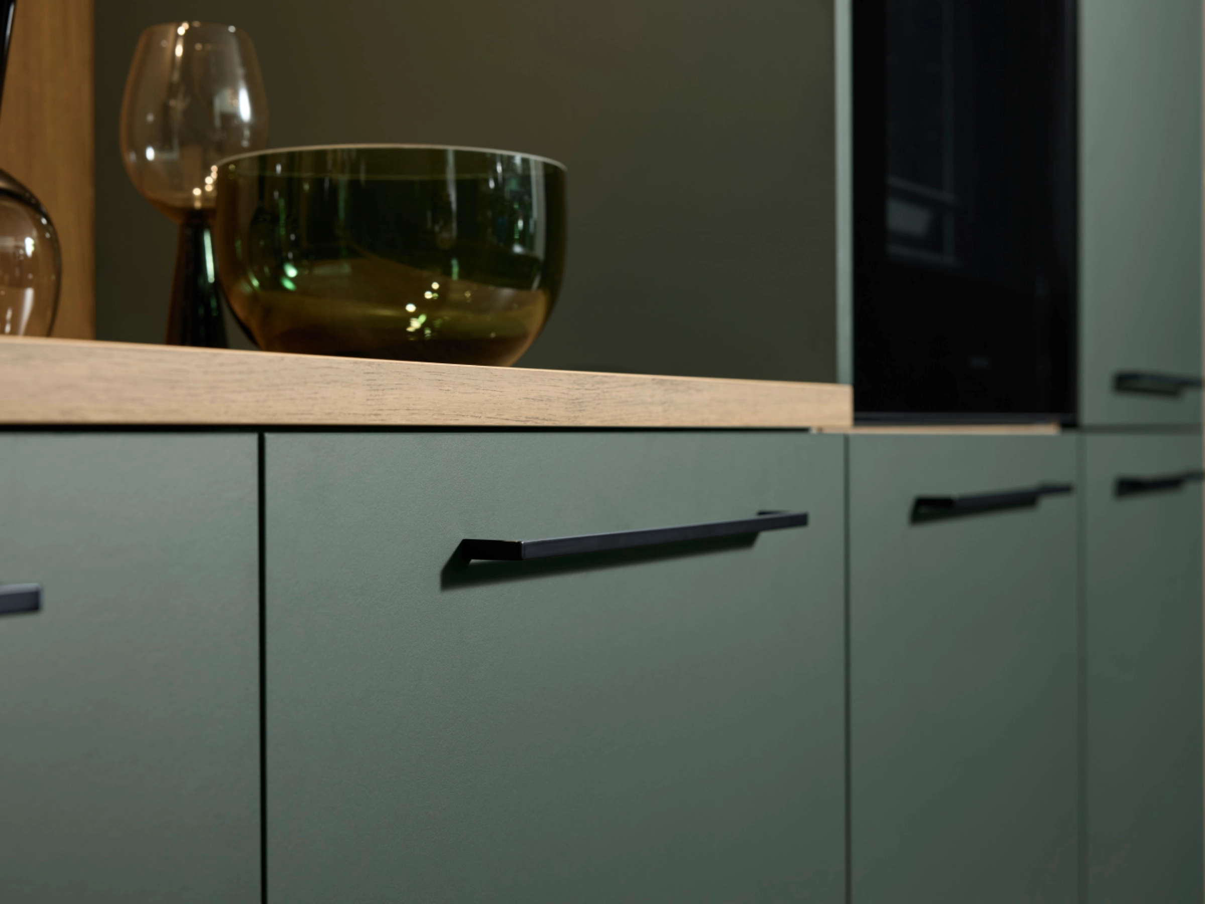 Armoires de cuisine modernes avec façades vertes et poignées noires de Nolte Kitchen.
