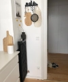 Un couloir avec un sol en bois et des objets muraux décoratifs, présenté par Nolte Kitchen.