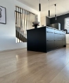 Cuisine moderne avec îlot noir et lampes suspendues, par Nolte Kitchen.
