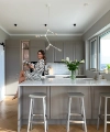 Une femme est assise sur un îlot de cuisine moderne avec des fleurs, Nolte Kitchen.