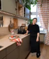 In der modernen Nolte Küchen steht eine Frau an der Arbeitsplatte mit Holzbrett und Gläsern.