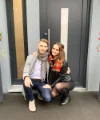 Una coppia seduta davanti a una porta moderna, circondata da piante decorative.