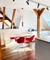 Une cuisine moderne avec poutres en bois et chaises rouges sous une fenêtre de toit. Nolte Kitchen.