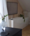 Dans un salon moderne, un buffet blanc décoré de plantes se trouve sous une télévision murale. Nolte Living.