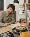 A man working at a desk in a modern Nolte Kitchen kitchen.