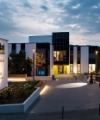 Le bâtiment moderne du Nolte Forum au crépuscule, entouré de chemins éclairés et d'espaces verts.