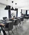 Une salle à manger élégante avec une longue table et des luminaires modernes de Nolte Living.
