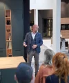 Mężczyzna przemawia przed grupą w nowoczesnej kuchni Nolte Kitchen.