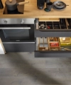Open drawers in a modern kitchen reveal cutlery and utensils, Nolte Kitchen.