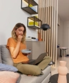 A woman sits with a laptop on a sofa in a modern room. Nolte Living.