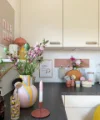 Eine helle Küche mit Blumen und Dekorationen auf der Arbeitsplatte. Nolte Küchen.