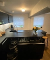 Cuisine moderne avec armoires sombres et îlot, équipée par Nolte Kitchen.