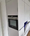 Eine moderne Einbauküche mit weißen Schränken und integriertem Backofen, von Nolte Küchen.