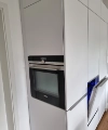 Eine moderne Einbauküche mit weißen Schränken und integriertem Backofen, von Nolte Küchen.