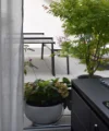 Ein moderner Außenbereich mit Pflanzen und Sitzmöbeln auf einer Terrasse.