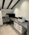 Studio moderno con scrivania, sedie e stampante sotto un tetto spiovente. Nolte Living.
