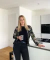 Eine Frau steht in einer modernen Küche mit weißen Schränken, Nolte Küchen.