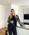 Une femme se tient dans une cuisine moderne avec des armoires blanches, Nolte Kitchen.