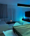 Ein modern beleuchtetes Wohnzimmer mit Sofa und Esstisch, ergänzt durch Nolte Living.