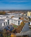 Ein modernes Gebäude mit großen Glasfronten, umgeben von einer herbstlichen Landschaft, ist zu sehen. Nolte Küchen.