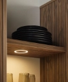 Ein Regal mit schwarzen Tellern und Gläsern in einem stilvollen Design von Nolte Living.