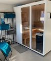 Un sauna moderne avec un transat bleu et des étagères, partie de Nolte SPA.