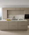 Cuisine moderne avec grande îlot, armoires claires, entourée de grandes fenêtres, Nolte Kitchen.