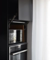Un meuble de cuisine moderne avec four et micro-ondes, conçu avec élégance par Nolte Kitchen.