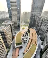 Modern skyscrapers with green roofs surrounded by urban landscape.