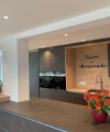 Cucina moderna con armadi scuri e tulipani sul bancone, design di Nolte Kitchen.